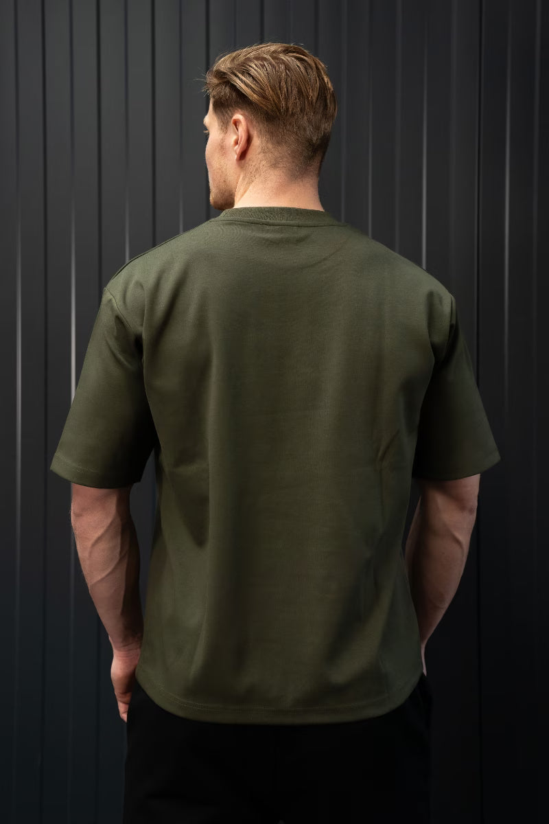 Man met een groen T-shirt tegen een zwarte achtergrond