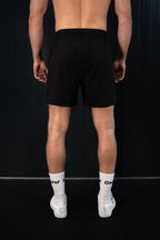 Back view of man wearing lightweight black On My Weights shorts – comfortabele heren short met elastische tailleband.