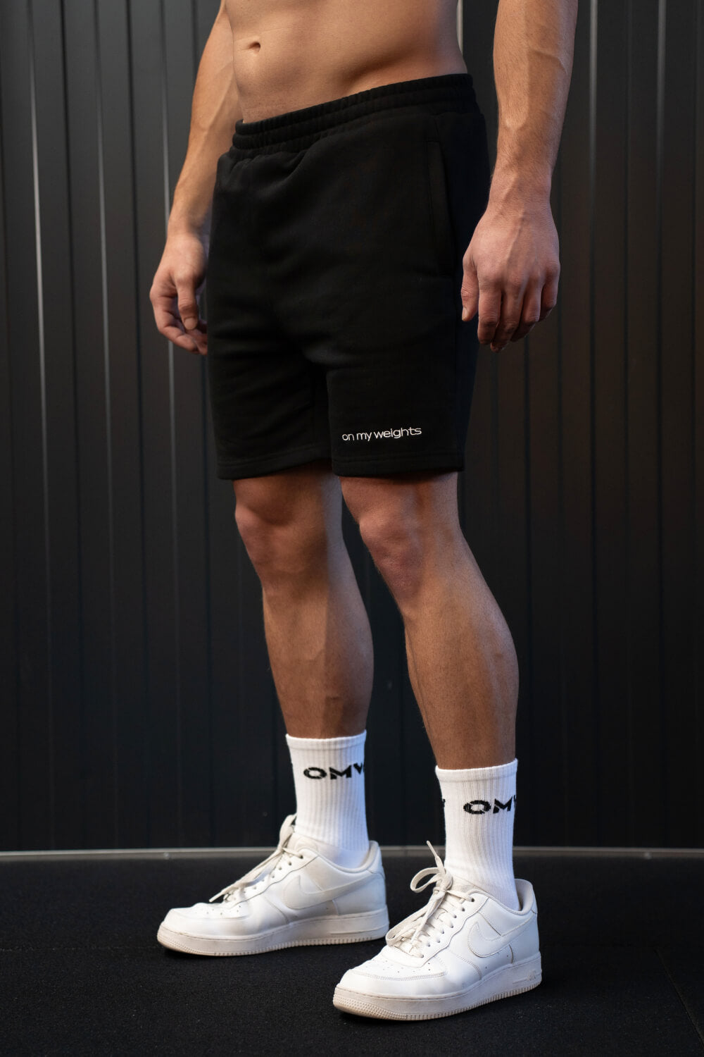 Model wearing On My Weights black shorts – athletic fit gymshorts, stijlvolle sportkleding voor training of casual wear.