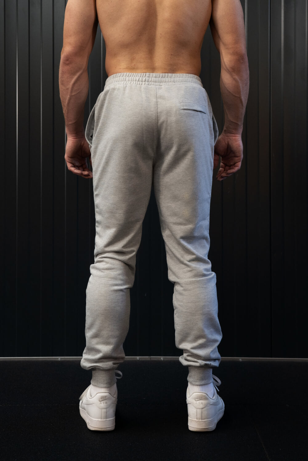 Back view of man wearing grey On My Weights joggers – grijze heren joggers met elastische tailleband en aansluitende pasvorm.