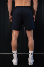 Back view of man wearing navy On My Weights shorts – donkerblauwe heren short met elastische tailleband en comfortabele fit.