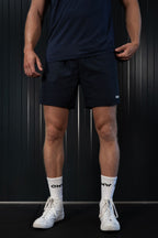 Man wearing navy On My Weights shorts – donkerblauwe sportshorts voor heren, lichte en ademende gymwear look.