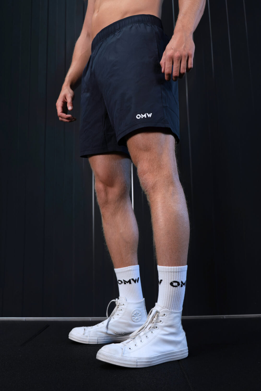 Model in navy On My Weights shorts – lichtgewicht trainingsshort met OMW logo, ideaal voor sport en workout.