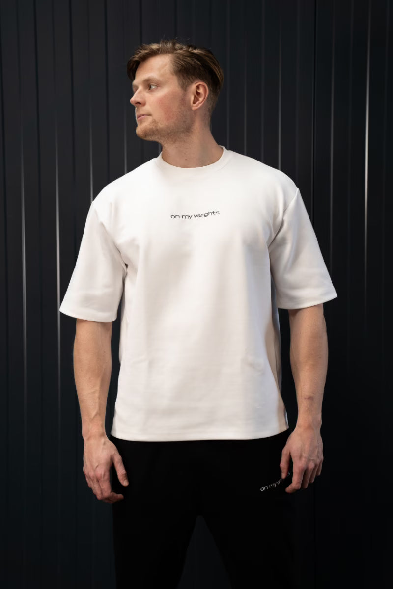 Man met een wit T-shirt met tekst op een zwarte achtergrond.
