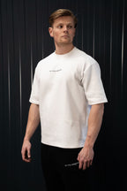 Man met een wit T-shirt met tekst op een zwarte achtergrond.