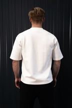 Persoon met een effen wit T-shirt tegen een zwarte achtergrond