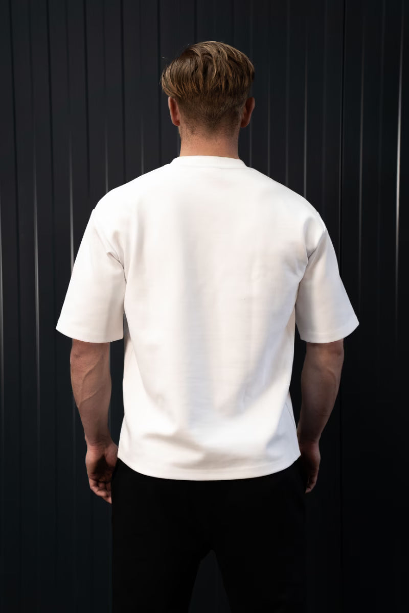 Persoon met een effen wit T-shirt tegen een zwarte achtergrond