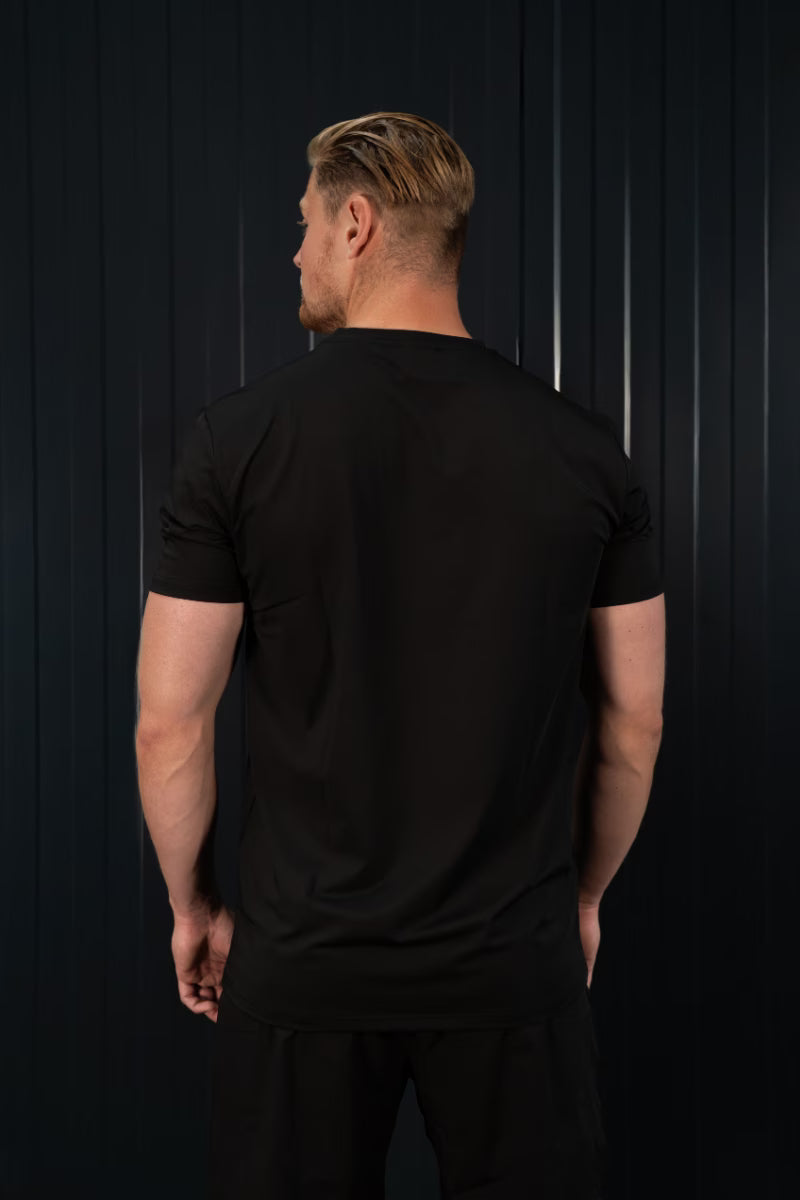 Man met zwart sport T-shirt voor een donkere achtergrond